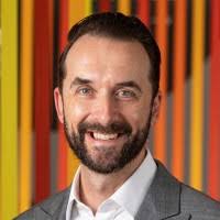 A headshot image of Brett Szmajda, Deputy Director of the National AI Centre