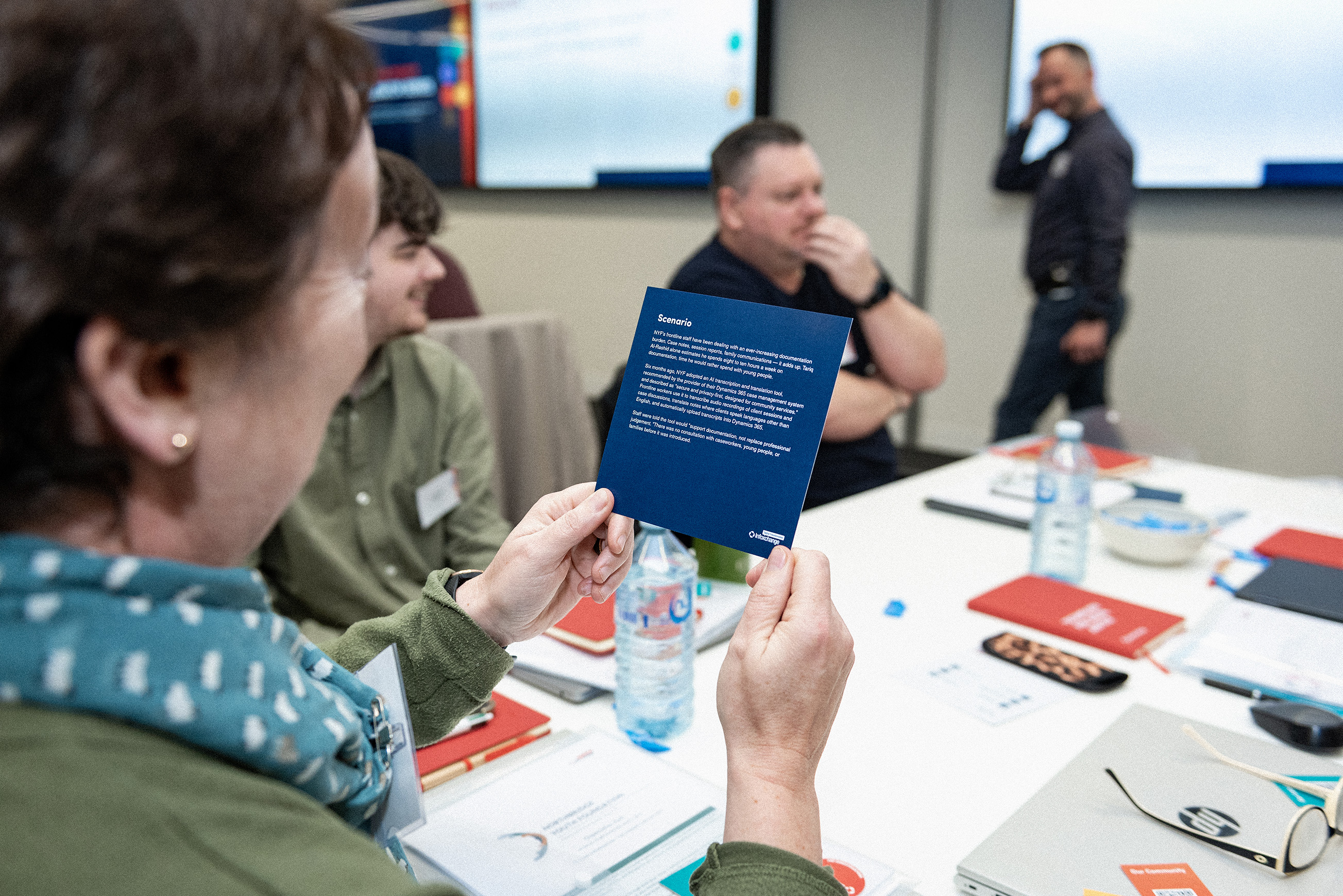 Colleagues sit around a table looking at printed information and having a discussion.