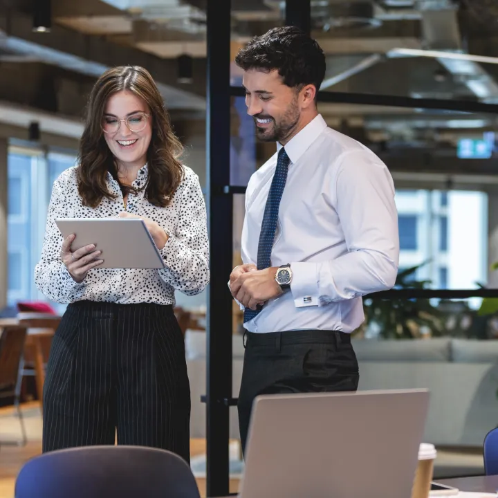 Woman and man looking at tablet device in the workplace.