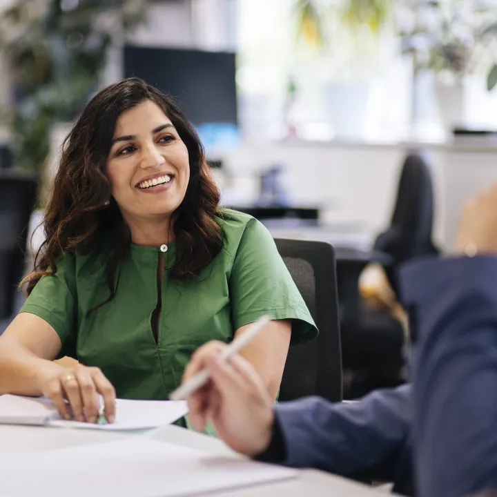 Two people talking at conference table