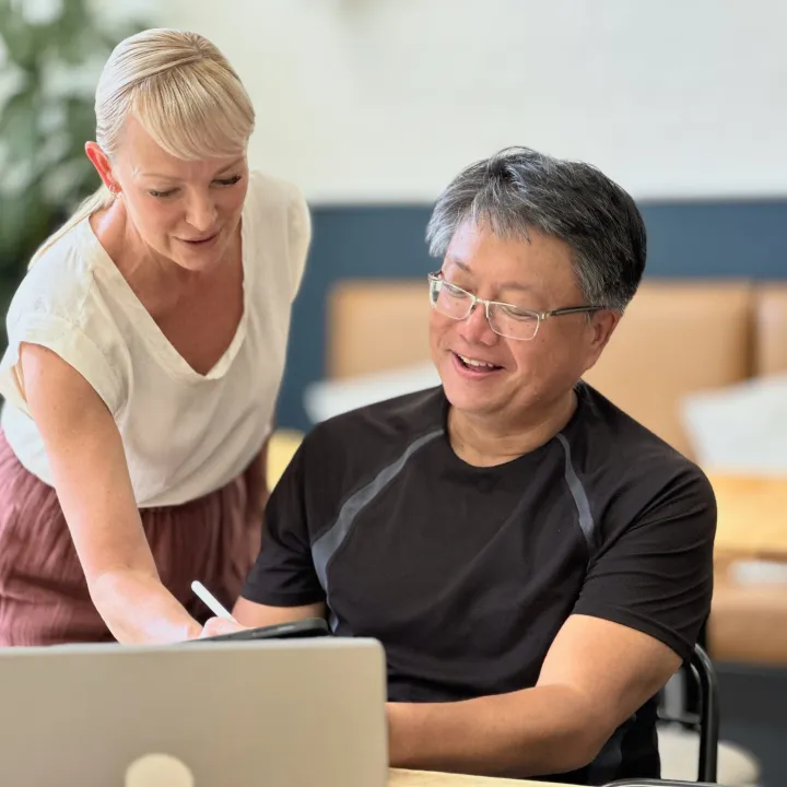 Two business colleagues in discussion, working at a computer.