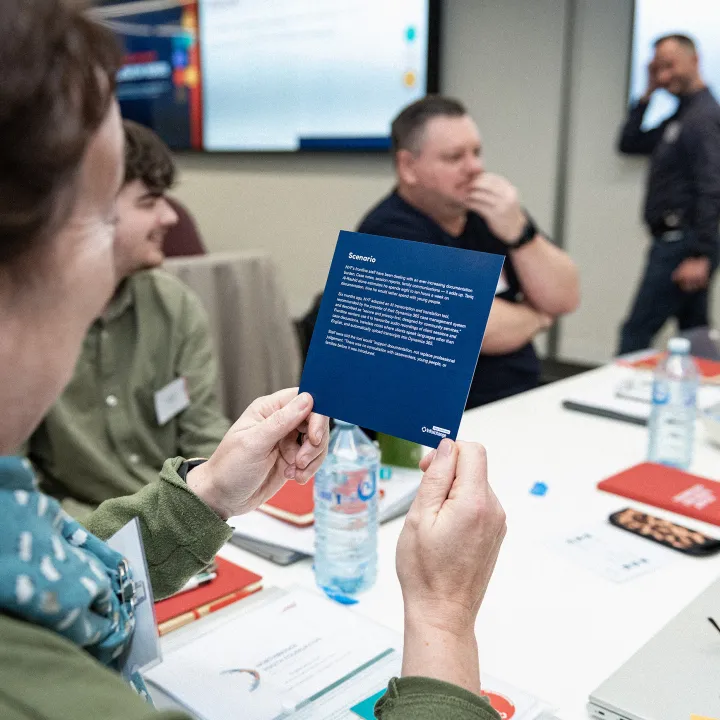 Colleagues sit around a table looking at printed information and having a discussion.