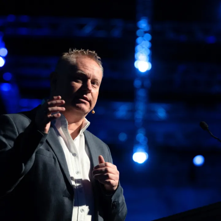 National AI Centre Executive Director Lee Hickin speaking onstage at the AI Leadership Summit 2025.